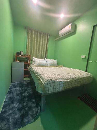ein Schlafzimmer mit einem Bett in einem grünen Zimmer in der Unterkunft Simple Garden Resort in Ko Phangan