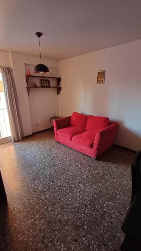 un sofá rojo sentado en una sala de estar en Departamento en pleno centro en Mendoza