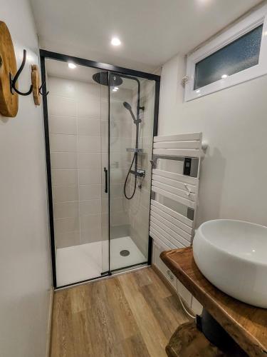 une salle de bain avec une douche en verre et un lavabo dans l'établissement Agréable maison rénovée en hyper centre avec patio, à Pornic