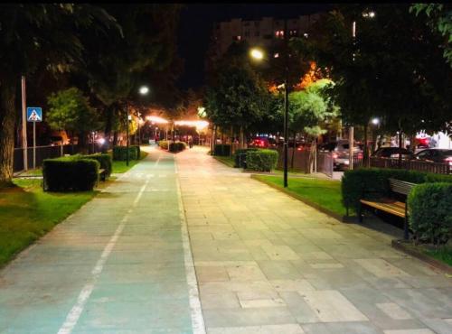 an empty sidewalk at night with benches and lights at Hotel Tbilisi Guest Home in Tbilisi City
