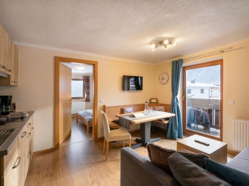 a kitchen and living room with a table and a couch at Haus Alpenrose in Waidring