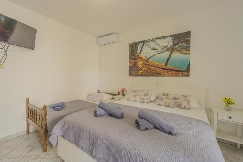 a bedroom with two beds and a painting on the wall at Katarina 1 in Zubovići