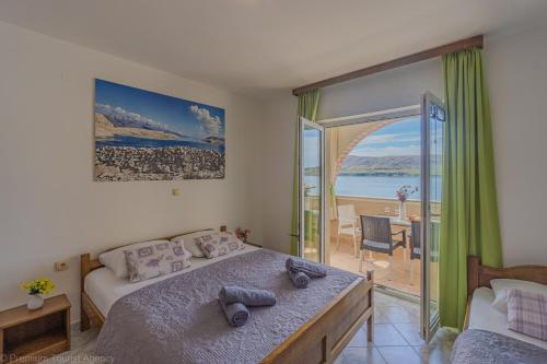 a bedroom with a bed and a view of the ocean at Katarina 1 in Zubovići