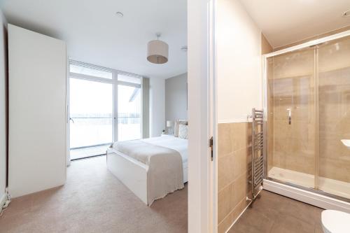 a white bedroom with a bed and a shower at The Thames Collection in London