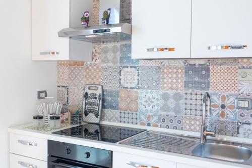a kitchen with white cabinets and a sink at Sole e Girasoli in Molfetta