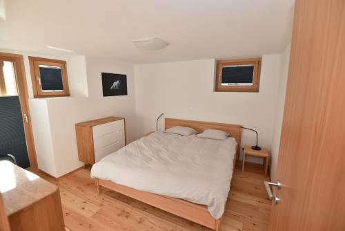 a bedroom with a bed with white sheets and two pillows at Fantastic renovated Chalet in the heart of Alps in Münster