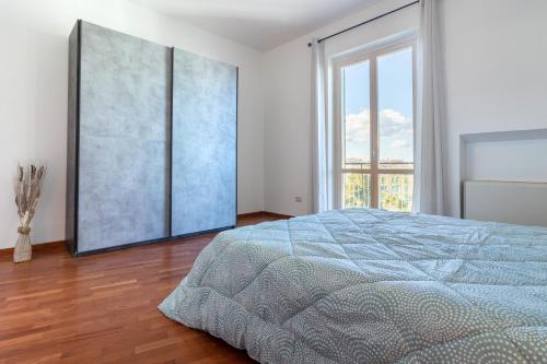 a bedroom with a bed and a large window at Sole e Girasoli in Molfetta