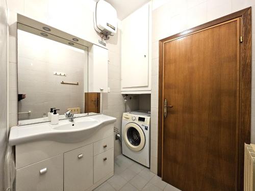 un bagno con lavandino e lavatrice di Matteo's Apartments Cecina Mare a Cecina