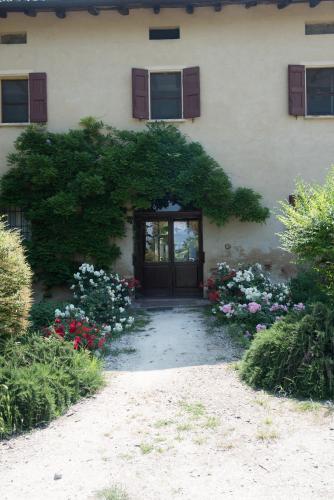 a building with a door with a bunch of flowers at Agriturismo Montevecchio Isolani in Monte San Pietro