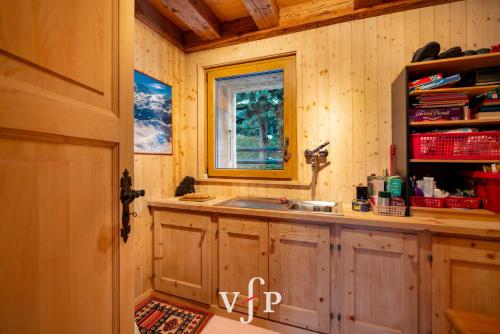 a kitchen with a sink and a window at L'Alouvy Winter Dream Chalet for Family at Verbier in Verbier