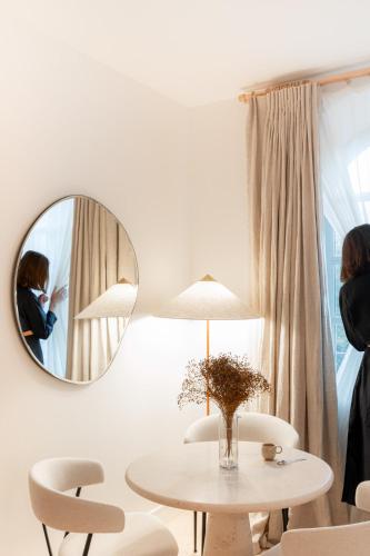a white room with a table and a mirror at Le Couvent des Minimes, un Hôtel & Spa L'Occitane en Provence in Mane