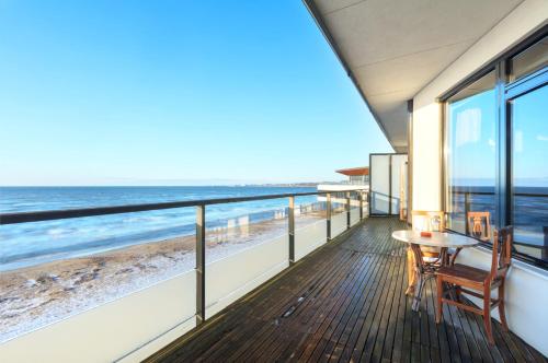 a balcony with a table and chairs and a view of the beach at Pirita Sea View Apartments One bedroom in Tallinn