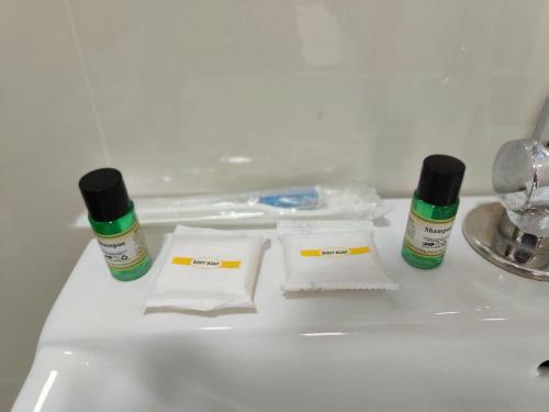 a sink with two bottles of medicines and towels at Lemon Hotels in Jamshedpur