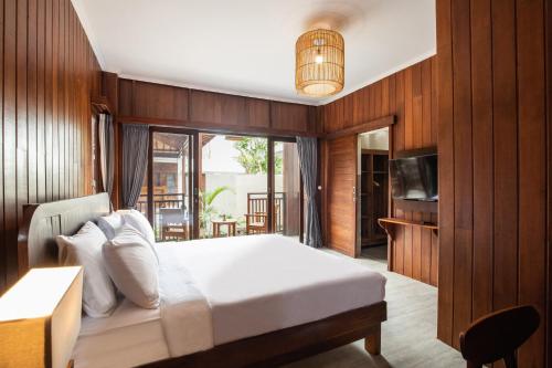 a bedroom with a large bed and a television at DADEKA Canggu in Canggu