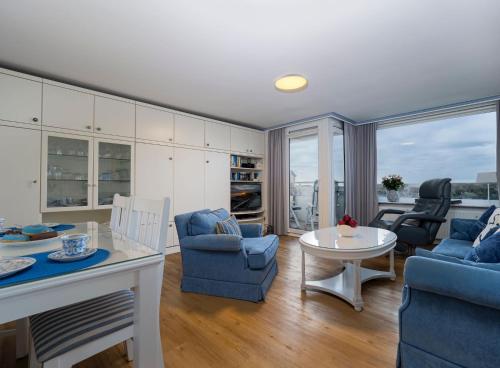 ein Wohnzimmer mit blauen Stühlen und einem Tisch in der Unterkunft Appartement Strandnah in Westerland