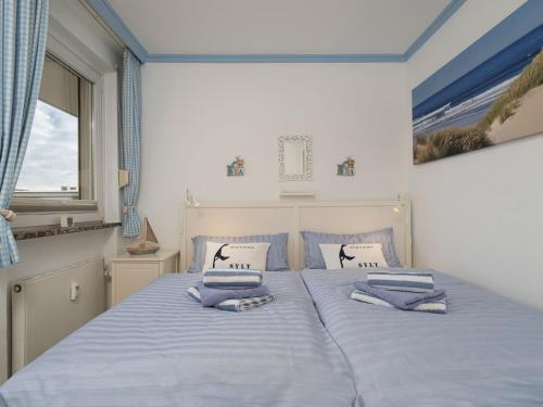 ein Schlafzimmer mit einem Bett mit zwei Kissen darauf in der Unterkunft Appartement Strandnah in Westerland