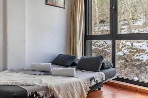 een bed in een kamer met een groot raam bij Monte Gorbea 7 I in Sierra Nevada