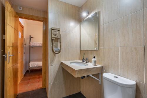 een badkamer met een wastafel, een toilet en een spiegel bij Monte Gorbea 7 I in Sierra Nevada