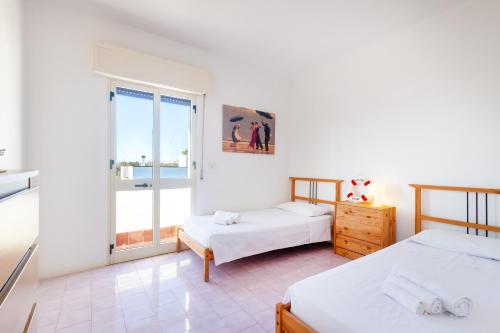 1 Schlafzimmer mit 2 Betten und einem Fenster in der Unterkunft Villa Salsedine in Porto Cesareo