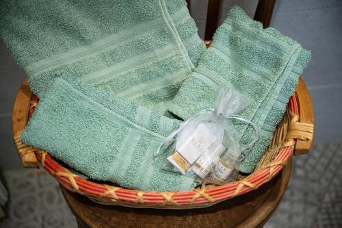 um cesto cheio de toalhas verdes numa mesa em La Rocca del Pellegrino em Carbonia