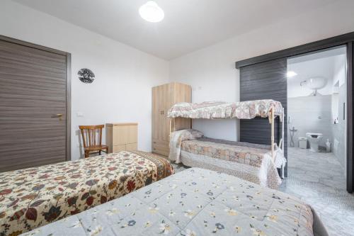 une chambre d'hôtel avec deux lits et une chaise dans l'établissement La Rocca del Pellegrino, à Carbonia