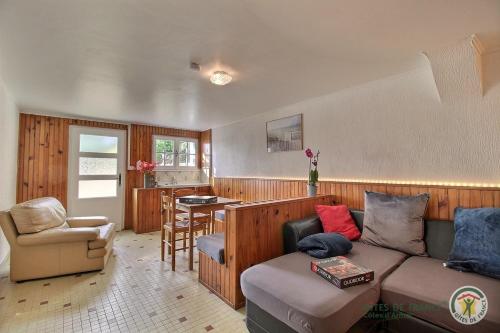 un salon avec un canapé et une chaise dans l'établissement La maison de tredrez, à Kerouguel