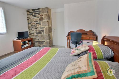 une chambre avec un lit et un mur en pierre dans l'établissement Denise et jean, à Bas Kerhain