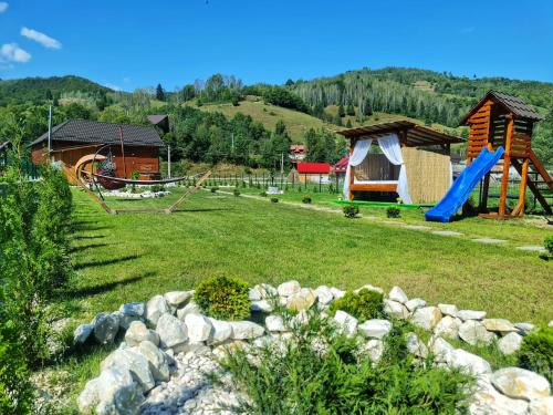 a park with a playground and a slide at Cabana Dintre Munti in Vidra