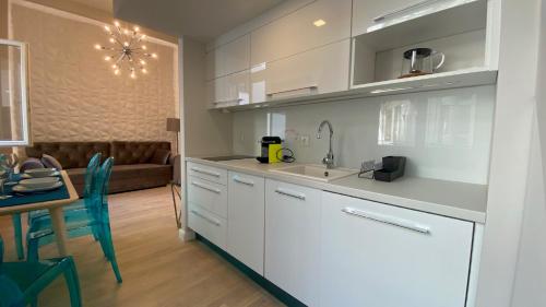 a kitchen with white cabinets and a table and a couch at Ocean Blue Apartment near the river in Budapest