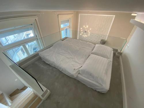 a white bed in a room with a window at Ocean Blue Apartment near the river in Budapest