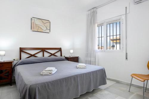 um quarto com uma cama com duas toalhas em Chalet con Piscina y Barbacoa 4 d em Chiclana de la Frontera