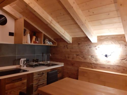 cocina con paredes de madera y mesa de madera en CASERA ONORINA Val Visdende, en Santo Stefano di Cadore