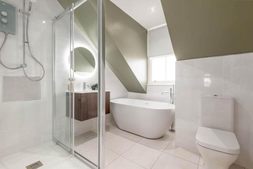 a bathroom with a shower and a tub and a toilet at Skye Sands - 11 Alexandra Penthouse - St Andrews in St Andrews