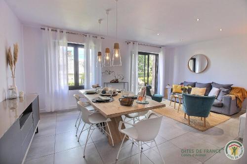 une cuisine et un salon avec une table et des chaises dans l'établissement Les oliviers, à Perros-Guirec