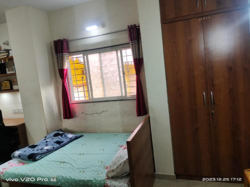 niewielka sypialnia z łóżkiem i oknem w obiekcie Matoshree Nivas w mieście Lohogaon