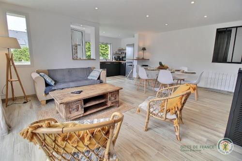 un salon avec un canapé et une table dans l'établissement La maison du golf, à Pleumeur-Bodou