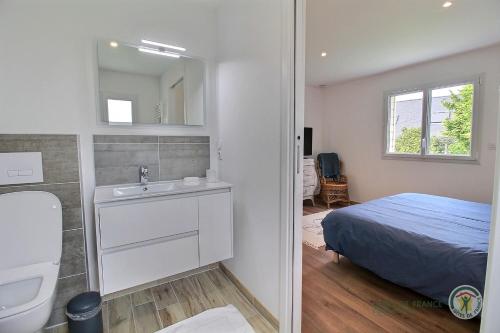 une chambre avec un lit, un lavabo et un miroir dans l'établissement La maison du golf, à Pleumeur-Bodou