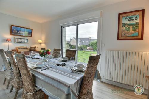 une salle à manger avec une longue table et des chaises dans l'établissement Beg ar lann, à Pleumeur-Bodou