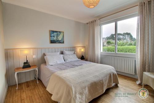 a bedroom with a bed and a large window at Beg ar lann in Pleumeur-Bodou