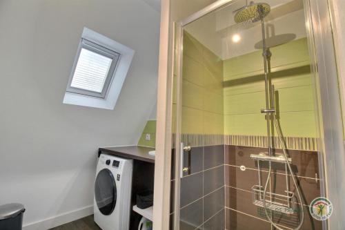 La salle de bains est pourvue d'une douche avec une porte en verre. dans l'établissement La terrasse sur le golf, à Pleumeur-Bodou