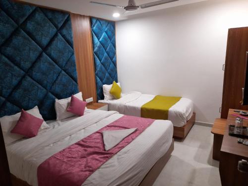 Habitación de hotel con 2 camas y almohadas coloridas en Hotel Era en Ahmedabad