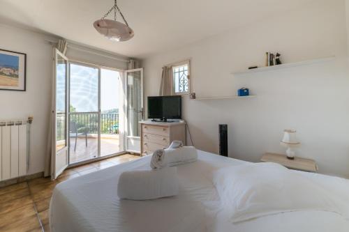 um quarto com uma grande cama branca e uma televisão em Villa Bellet em Nice