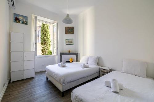 um quarto com 2 camas e uma janela em Grand 3P pour 6 Pers proche Palais à Cannes * idéal Congrès em Cannes