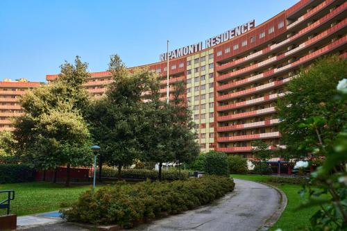 ein großes Gebäude mit einem Schild darauf in der Unterkunft Ripamonti Residence & Hotel Milano in Pieve Emanuele