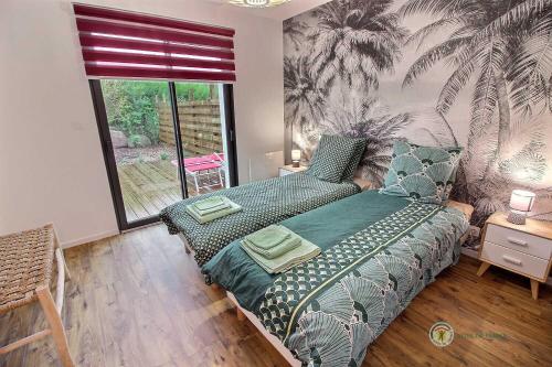 a bedroom with a bed and a large window at Le petit marius in Pleumeur-Bodou