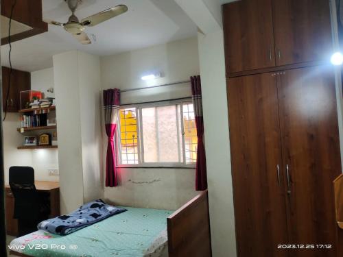niewielka sypialnia z łóżkiem i oknem w obiekcie Matoshree Nivas w mieście Lohogaon