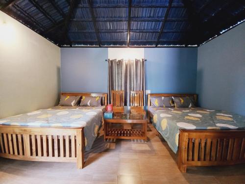 dos camas sentadas una al lado de la otra en una habitación en Sri Sai Nature Stay en Madikeri