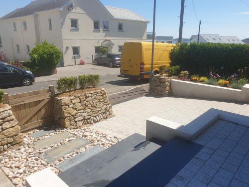 a yellow van is parked in a parking lot at Modern open plan house, sea views and hot tub in Falmouth