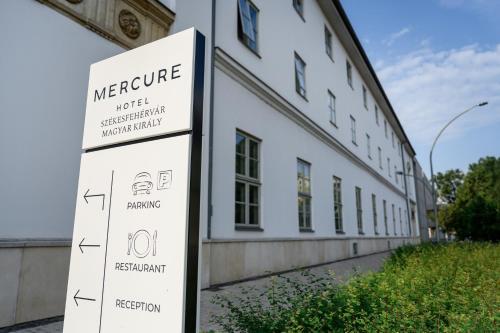 a sign in front of a white building at Mercure Szekesfehervar Magyar Kiraly in Székesfehérvár