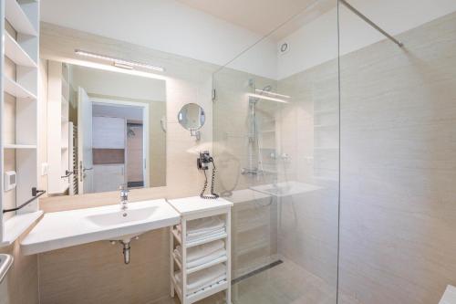 a bathroom with a sink and a glass shower at Appartements Thermen-Golfresort Pannonia in Zsira